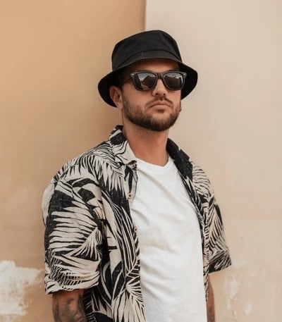 men wear a bucket hat with layering beach vacation looks