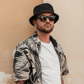 men wear a bucket hat with layering beach vacation looks